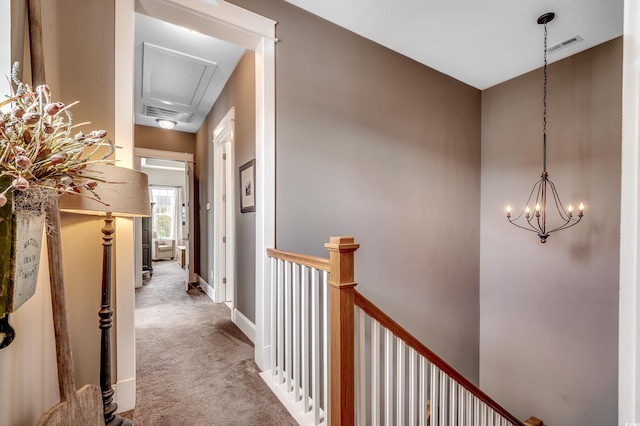 corridor with visible vents, carpet floors, baseboards, an inviting chandelier, and an upstairs landing