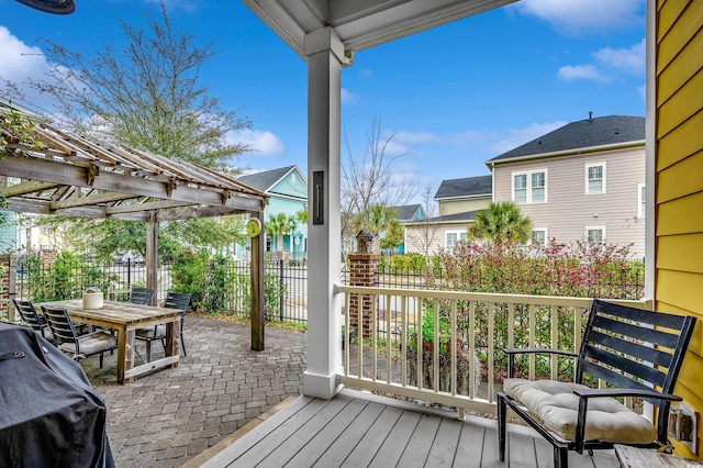 wooden terrace featuring a patio, fence, outdoor dining area, a pergola, and a grill