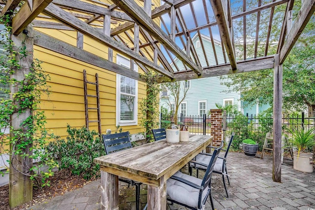 view of patio featuring outdoor dining space, a pergola, and fence