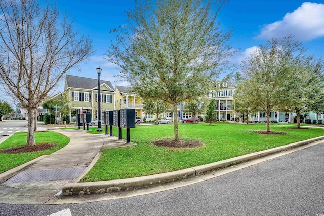 surrounding community featuring a lawn and mail area