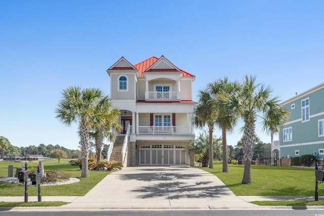 beach home featuring a front yard, stairway, a standing seam roof, concrete driveway, and metal roof