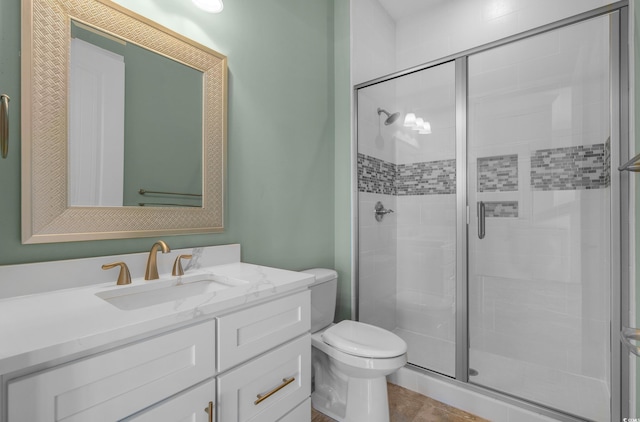 bathroom featuring tile patterned floors, toilet, a stall shower, and vanity