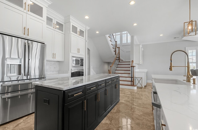 kitchen featuring dark cabinetry, a sink, decorative backsplash, stainless steel appliances, and white cabinetry