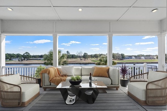 sunroom featuring a water view