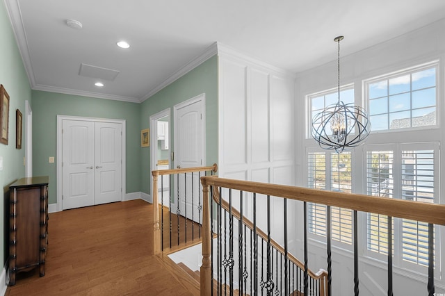 hallway featuring an upstairs landing, a chandelier, ornamental molding, and wood finished floors