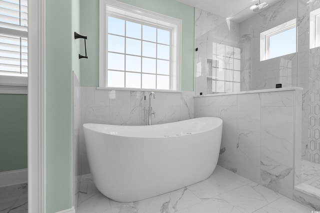 bathroom with a healthy amount of sunlight, marble finish floor, a marble finish shower, and a freestanding bath