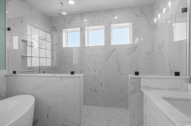 full bath featuring vanity, tile walls, a freestanding tub, and a marble finish shower