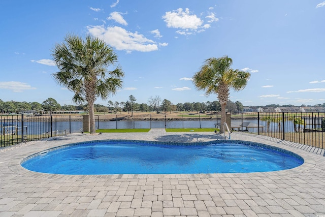 view of pool featuring a patio area, a fenced in pool, a water view, and fence