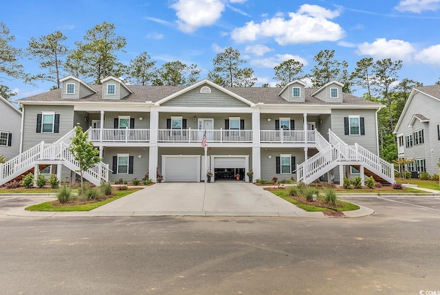 view of front of home featuring stairs, an attached garage, driveway, and roof with shingles