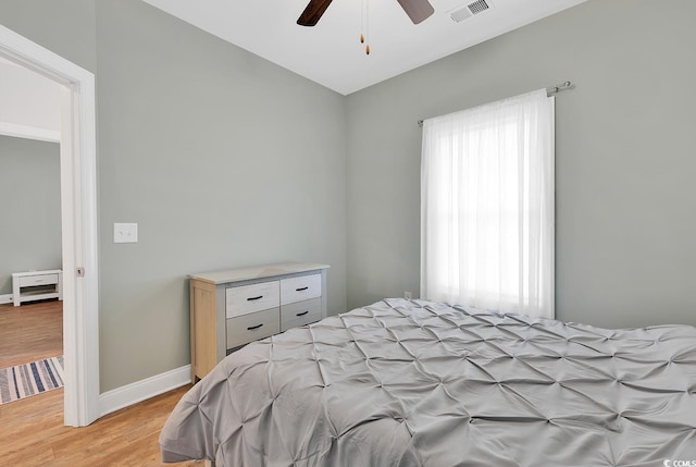 bedroom featuring visible vents, baseboards, light wood-style floors, and ceiling fan