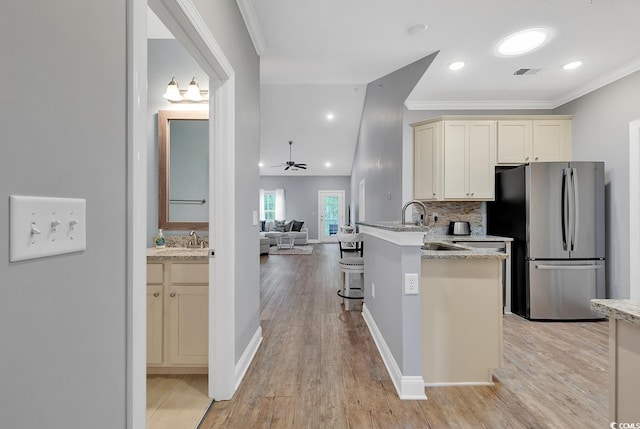 kitchen featuring light wood finished floors, visible vents, freestanding refrigerator, and ornamental molding