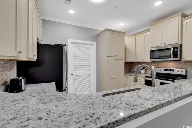 kitchen featuring stainless steel appliances, light stone countertops, visible vents, and crown molding