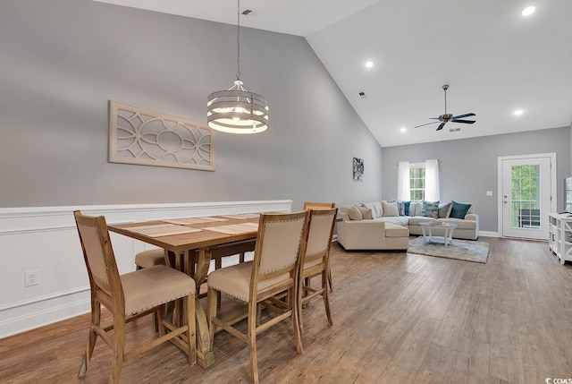 dining room featuring baseboards, high vaulted ceiling, ceiling fan, and wood finished floors