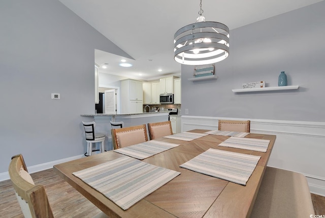 dining room featuring an inviting chandelier, recessed lighting, light wood finished floors, and wainscoting