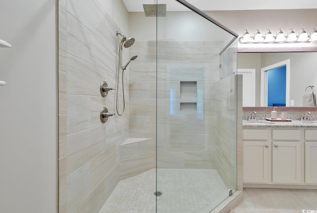 full bath featuring a shower stall, double vanity, and a sink