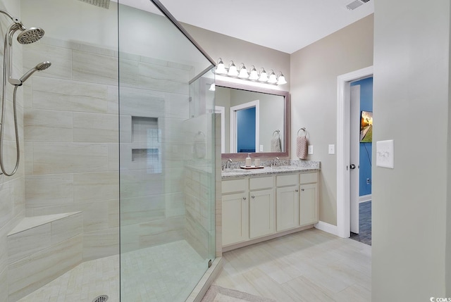 full bathroom with double vanity, a tile shower, and a sink