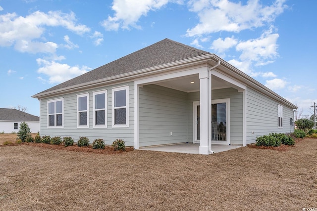 rear view of property featuring a patio area and a yard