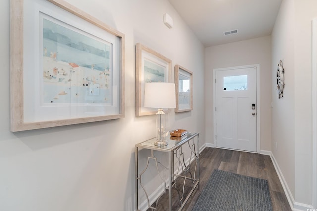 doorway to outside with dark wood finished floors and baseboards