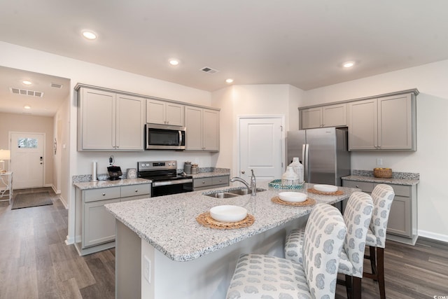 kitchen with stainless steel appliances, gray cabinetry, a sink, dark wood-type flooring, and recessed lighting