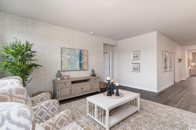 living area featuring wallpapered walls, baseboards, and wood finished floors