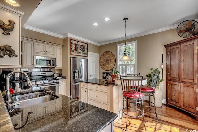 1539 Old Town Ave, Georgetown, SC 29440 - kitchen featuring appliances with stainless steel finishes, cream cabinets, light wood finished floors, pendant lighting, and crown molding