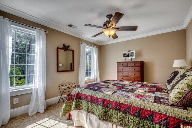 bedroom featuring baseboards, visible vents, ceiling fan, crown molding, and carpet flooring