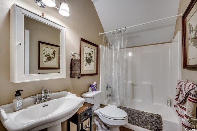 bathroom with shower / bathtub combination with curtain, toilet, and a sink