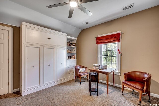 office area with visible vents, baseboards, light colored carpet, and vaulted ceiling