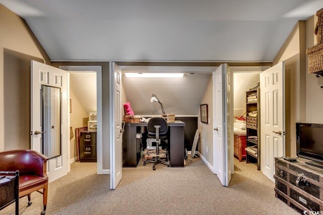 office space featuring vaulted ceiling, baseboards, and carpet floors