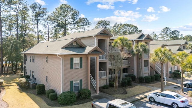 270 Pinehurst Ln Unit 9G, Pawleys Island, SC 29585 - view of building exterior featuring uncovered parking, central AC, and stairway
