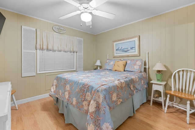 bedroom with a ceiling fan, crown molding, wood finished floors, and baseboards