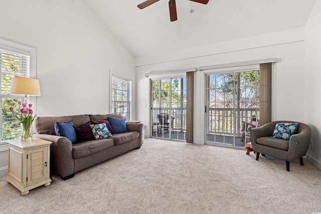 living room featuring high vaulted ceiling, a ceiling fan, and light carpet