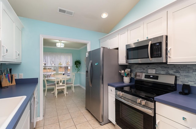 kitchen with light tile patterned floors, visible vents, stainless steel appliances, white cabinetry, and tasteful backsplash