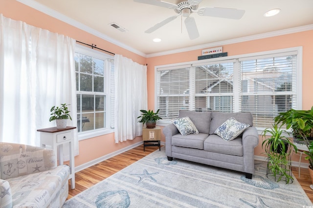 sunroom featuring a wealth of natural light, visible vents, and a ceiling fan