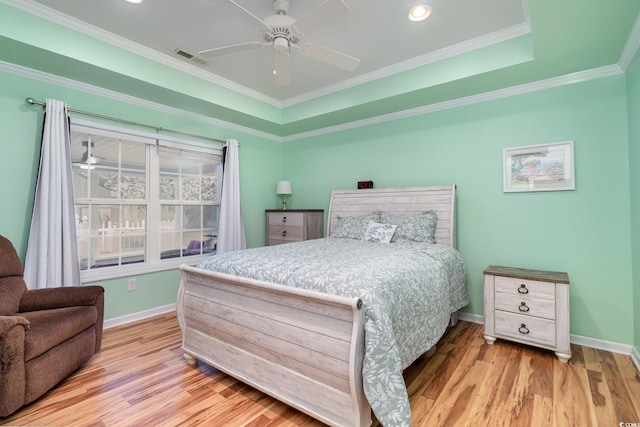 bedroom with visible vents, wood finished floors, baseboards, and ornamental molding