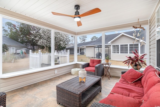 sunroom / solarium featuring a ceiling fan