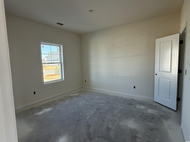 unfurnished room with visible vents, baseboards, and concrete floors