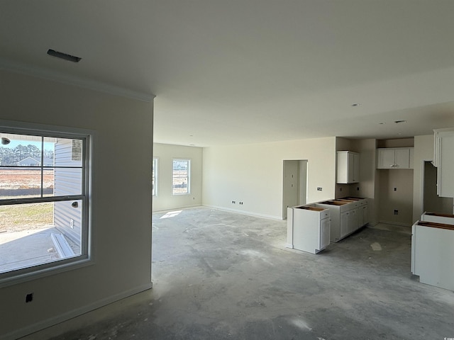 unfurnished living room featuring unfinished concrete floors and baseboards