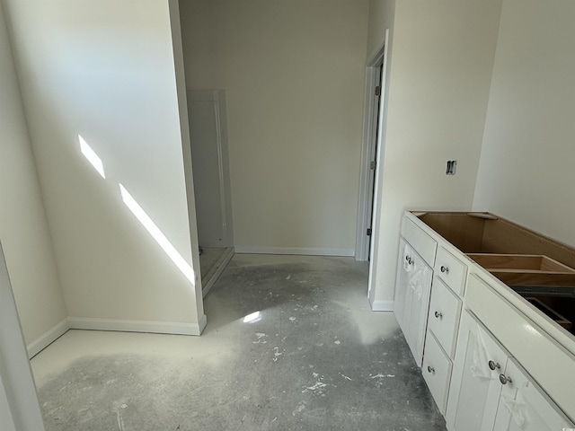 bathroom featuring unfinished concrete floors and baseboards