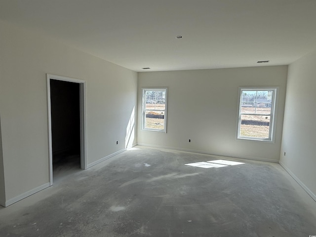 unfurnished room featuring visible vents, concrete flooring, and baseboards