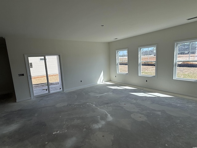 spare room with a wealth of natural light, visible vents, and unfinished concrete flooring