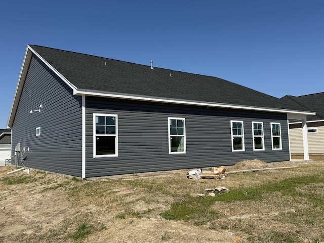 rear view of house with roof with shingles