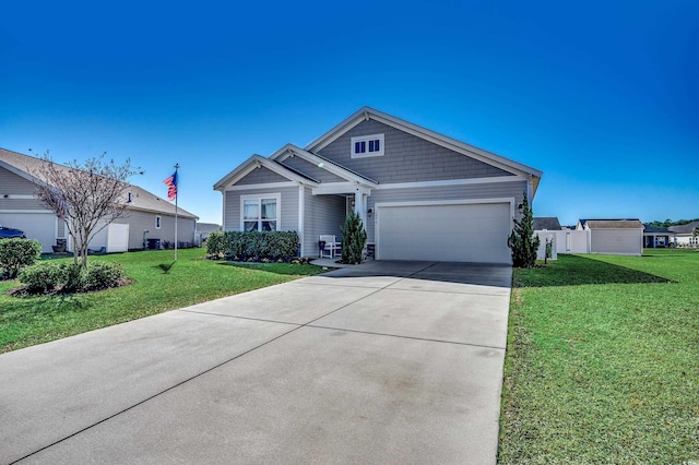 craftsman inspired home with an attached garage, concrete driveway, and a front lawn