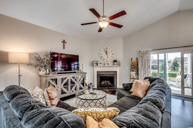 living area with a fireplace, vaulted ceiling, wood finished floors, and a ceiling fan