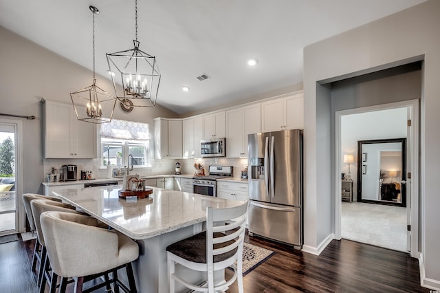 kitchen featuring a kitchen island, tasteful backsplash, appliances with stainless steel finishes, and white cabinetry