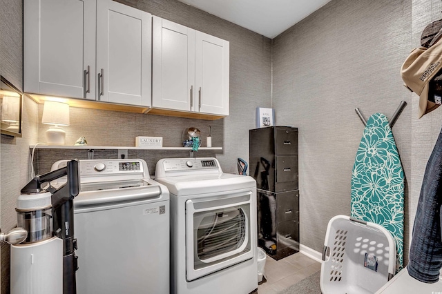 laundry area with cabinet space, light tile patterned floors, and independent washer and dryer