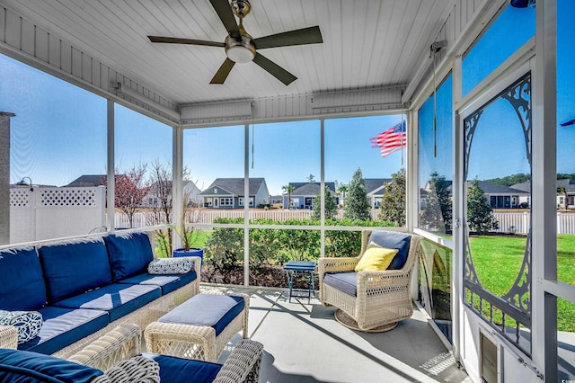 sunroom / solarium with a residential view and ceiling fan