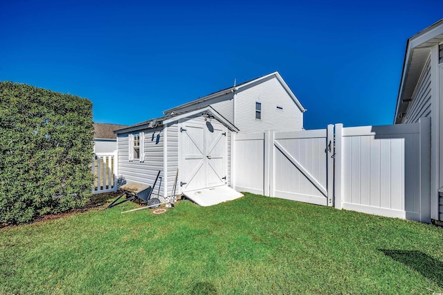 view of yard with a gate, a shed, an outdoor structure, and fence