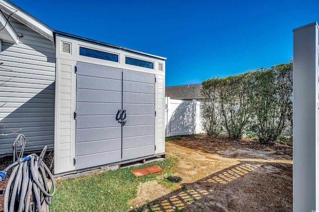 view of outbuilding featuring fence