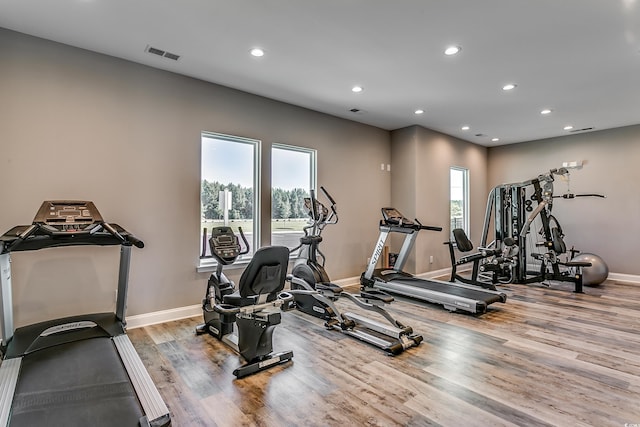 exercise room featuring recessed lighting, wood finished floors, visible vents, and baseboards